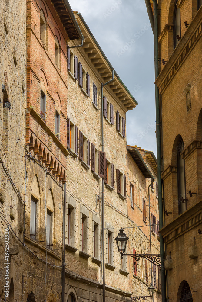 Facades of old houses in the historic center of Volterra, Italy