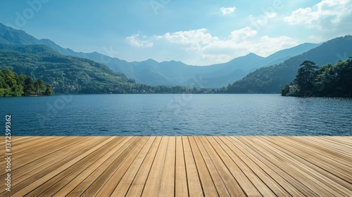 Serene lake vista from wooden deck with lush green mountains under a clear blue sky offering a tranquil scenic view for travel and relaxation