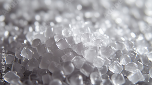 A close-up view of plastic polymer granulate shows small, uniform pellets ready for molding.

