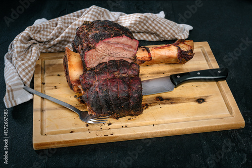 Beef Hammer, Rinderhaxe, Rinderwade, Gabe, Messer, auf Holzbrett auf schwarzem Schiefer, gegrillt, smoken, gesmoked