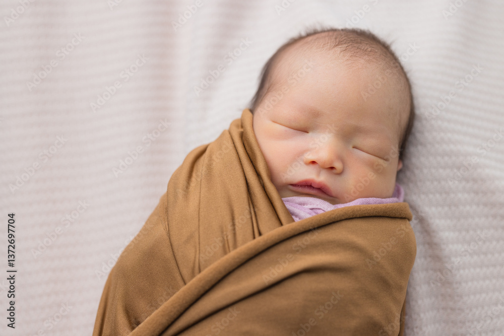 Wrapped newborn baby sleeping on soft surface