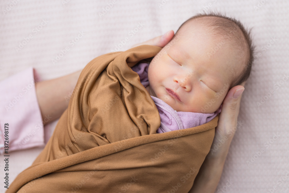 Caring mother cradling sleeping newborn baby