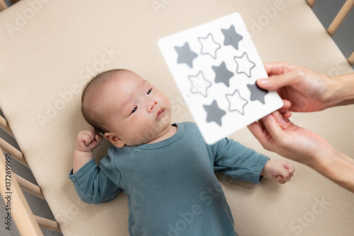 Obraz na płótnie Newborn baby watching black and white pattern card in crib w salonie