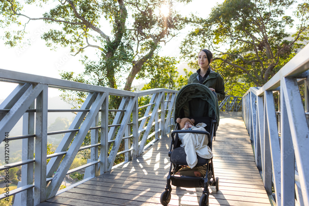 Hiking woman walk with baby stroller along trail