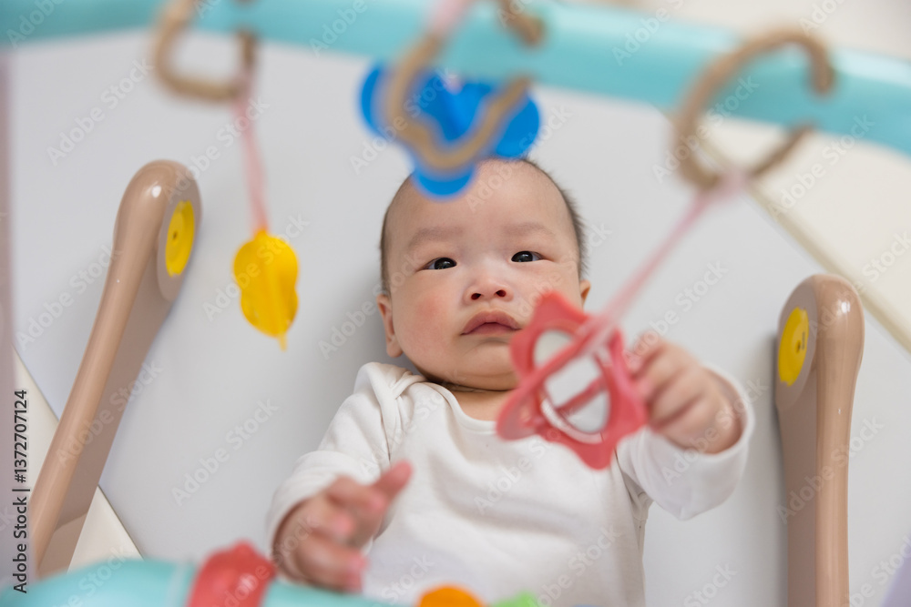 Baby Lying Under Play Gym For Fun And Motor Skills