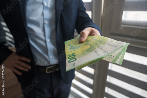Obraz na płótnie Man in suit holding euro banknotes, business.
w salonie