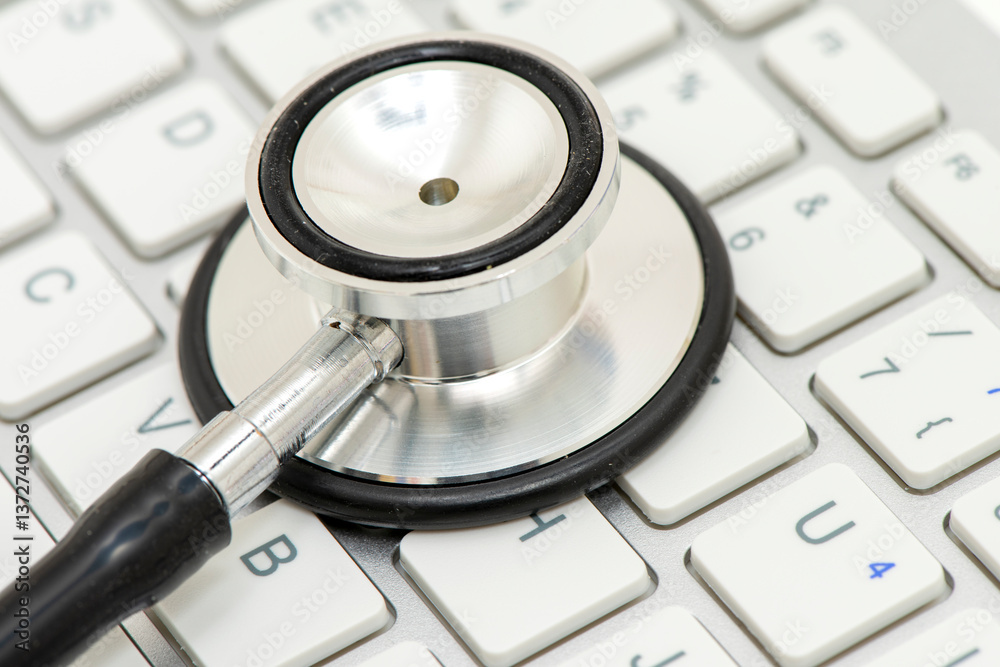 Ein medizinisches Stethoskop liegt auf einer Tastatur als Symbol für Bürokratie im Gesundheitswesen