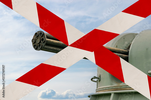 ship automatic gun crossed with white and red barrier tape. concept of prohibition of arms supplies to warring countries