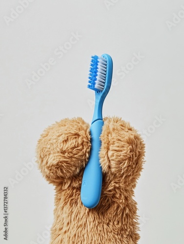 Teddy bear paw holding blue toothbrush	