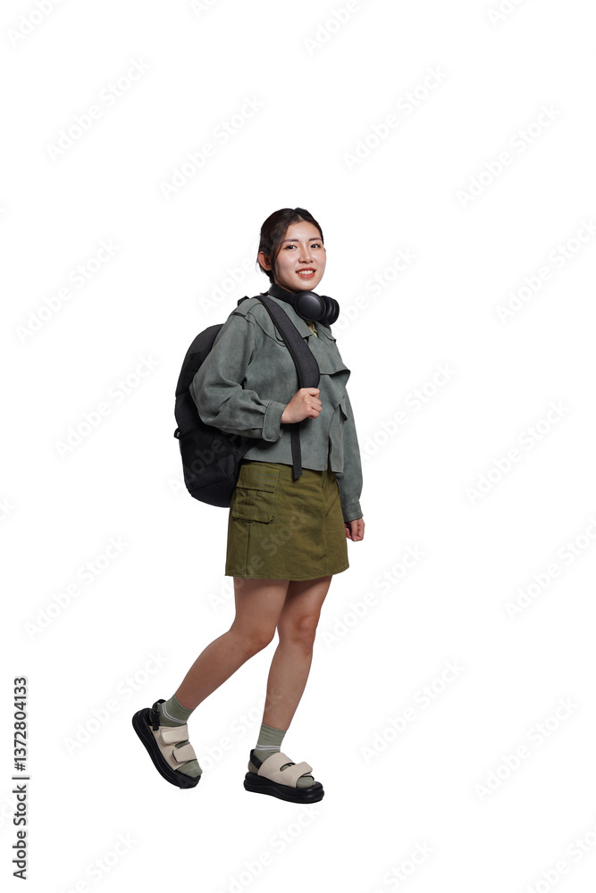 Portrait of Asian female student wearing backpack, headphones, fashionable clothes, posing dynamically on white background Portrait of Asian female student wearing backpack, headphones, fashionable clothes, posing dynamically on white background