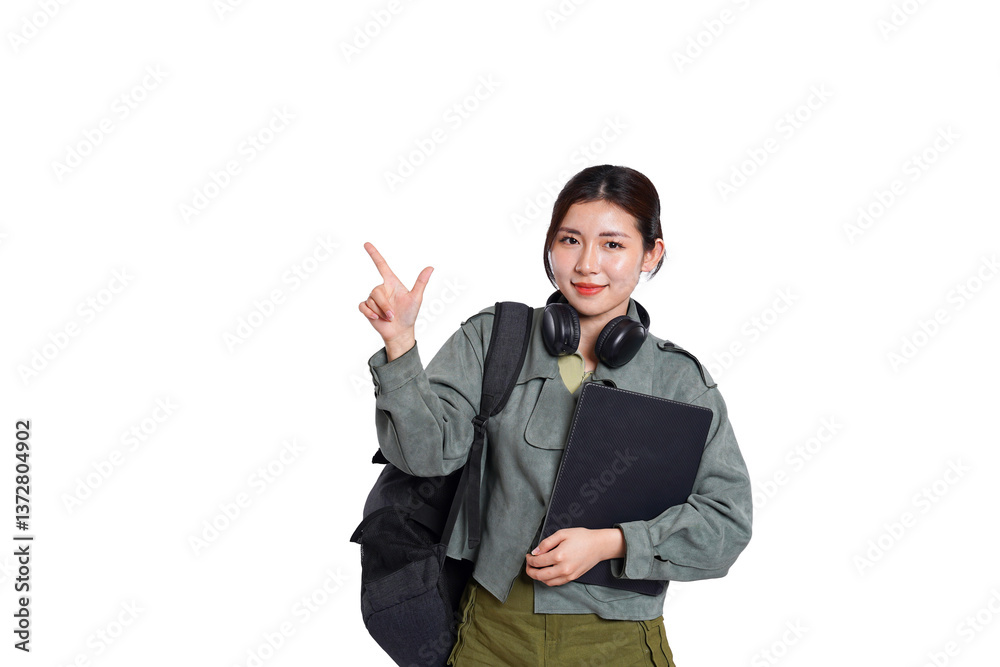 Portrait of Asian female student wearing backpack, headphones, fashionable clothes, holding laptop, posing dynamically on white background Portrait of Asian female student wearing backpack, headphones, fashionable clothes, holding laptop, posing dynamically on white background
