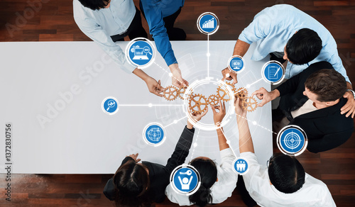 A diverse team engages in collaborative brainstorming, leveraging gear symbols and data icons to symbolize innovative strategies and effective teamwork in a modern office environment. Amity photo