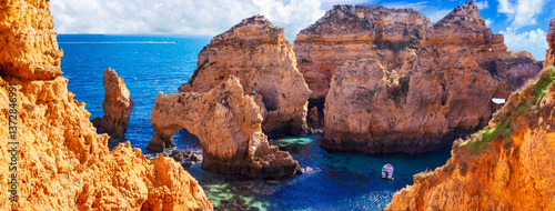 Amazing rocky scenic becahes of Algarve coast, Portugal. Breathtaking famous beach Praia da Marinha with yellow rocks with arc . panoramic view.