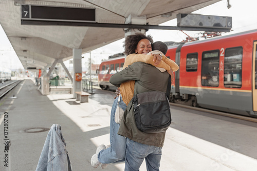 African American couple meeting at a railway station near arrived train, expressing excitement for their upcoming journey together.