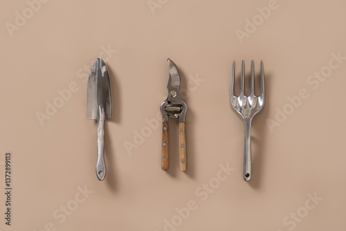 Obraz na płótnie Various gardening hand tools on beige background. Spring gardening. Concept season work. Wood and metal small sized hand cultivator. Top view. w salonie