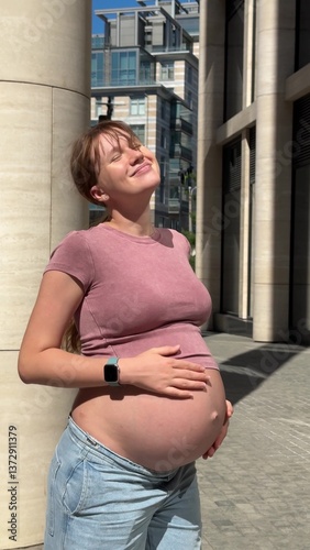portrait of beautiful pregnant woman in city, warm weather in third trimester