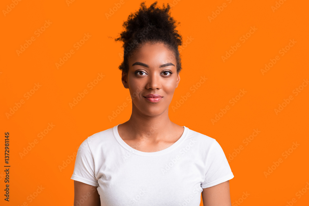 Headshot of young african american woman looking at camera isolated on yellow background Headshot of young african american woman looking at camera isolated on yellow background