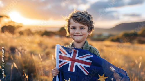 Smiling boy holding Australian flag against beautiful landscape, blue flag with red cross and stars, country symbol, patriot, child, Australia day, Anzac day