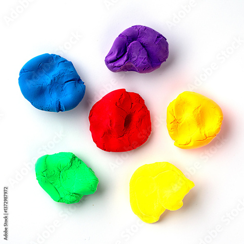 Colorful modeling clay in primary colors arranged on a white background