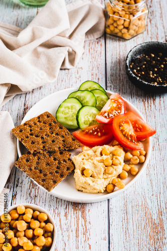 Obraz na płótnie Vegetarian plate with chickpeas and vegetables on the table vertical view w salonie