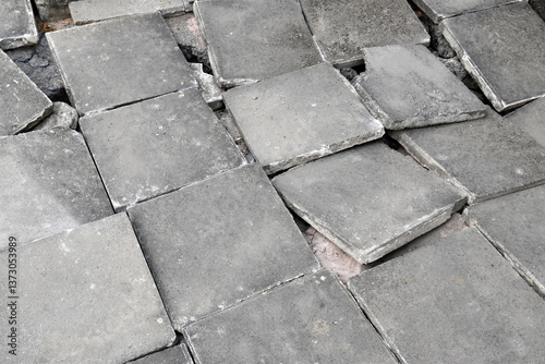grey concrete slabs tile floor damaged by earthquake, broken pavement tile ground, sidewalk destruction by disaster