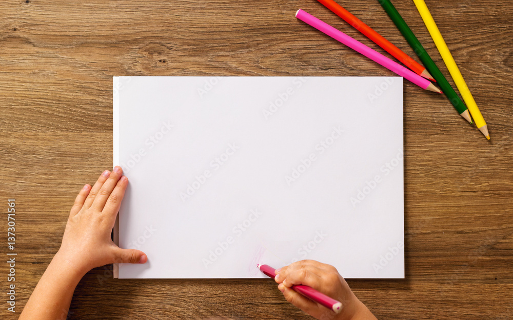 Child drawing on blank white paper top view