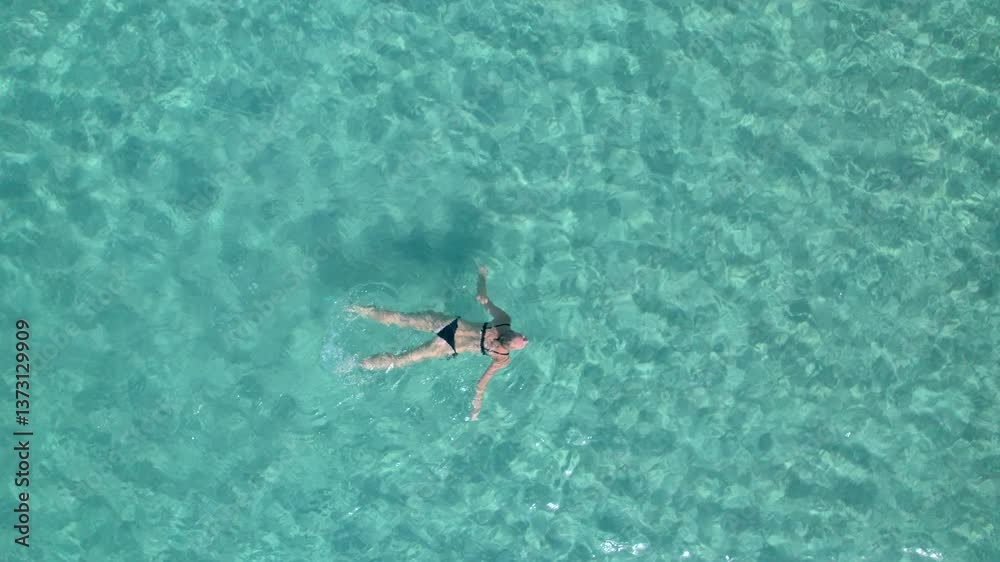 Tourist floating and relaxing on clear turquoise water Tourist floating and relaxing on clear turquoise water
