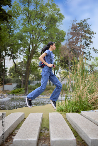 Energetic tourist jumping in park with backpack