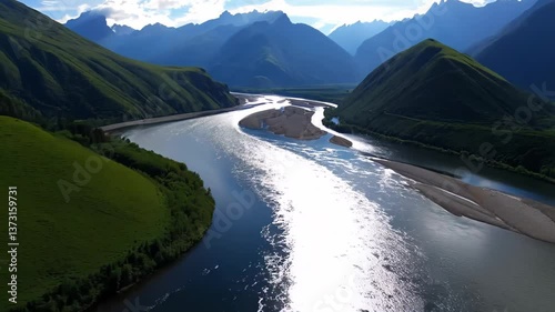 Wallpaper Mural Experience the beauty of a winding river flowing through green hills, with majestic mountains rising in the background under a clear sky. The peaceful vibe creates a perfect escape into nature Torontodigital.ca