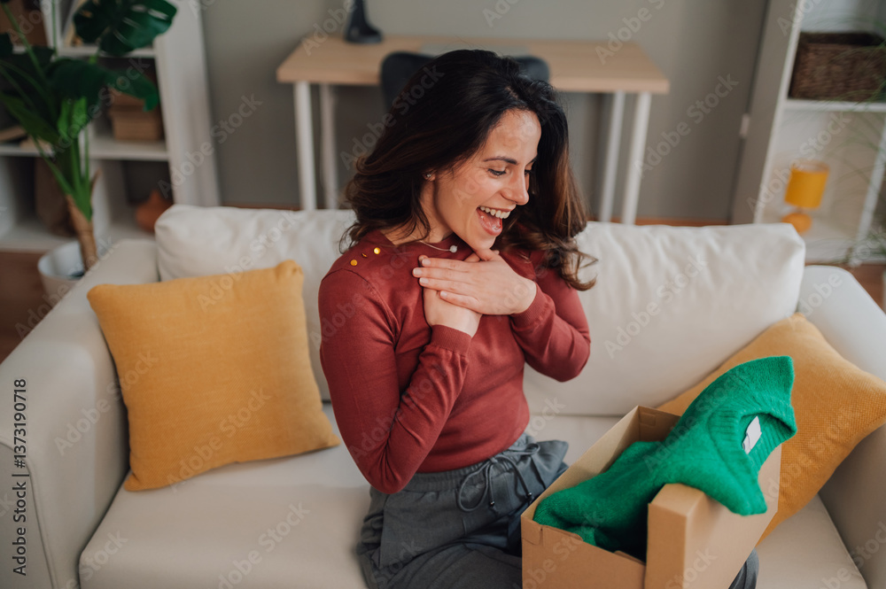 Fototapeta premium Happy woman opening a surprise gift box at home