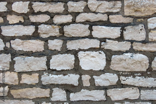 Light colored stone wall with dark black mortar