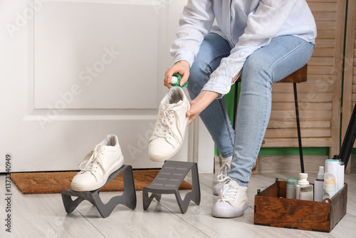 Woman cleaning stylish snea...