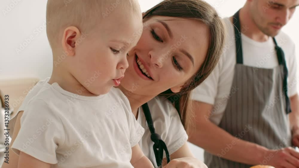 A mother lovingly engages with her toddler in a warm home setting, focusing on the child's curiosity while a father prepares nearby. The atmosphere reflects care and togetherness. A mother lovingly engages with her toddler in a warm home setting, focusing on the child's curiosity while a father prepares nearby. The atmosphere reflects care and togetherness.