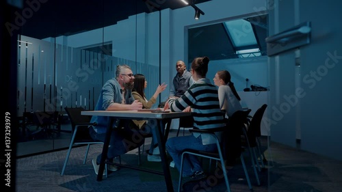 In a sleek glass office space, a team of business professionals engage in lively discussions and exchange strategic ideas, showcasing collaboration and innovation at the heart of modern corporate