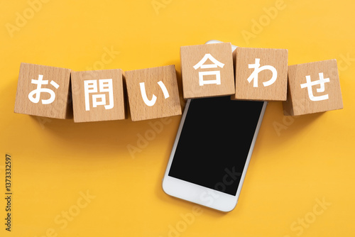 お問い合わせと書かれたブロックとスマホ