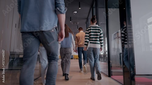 Business team in a modern open space startup office walking together. Diverse group of businesspeople smiling while having a discussion. Successful mixed race colleagues collaborating on a new project