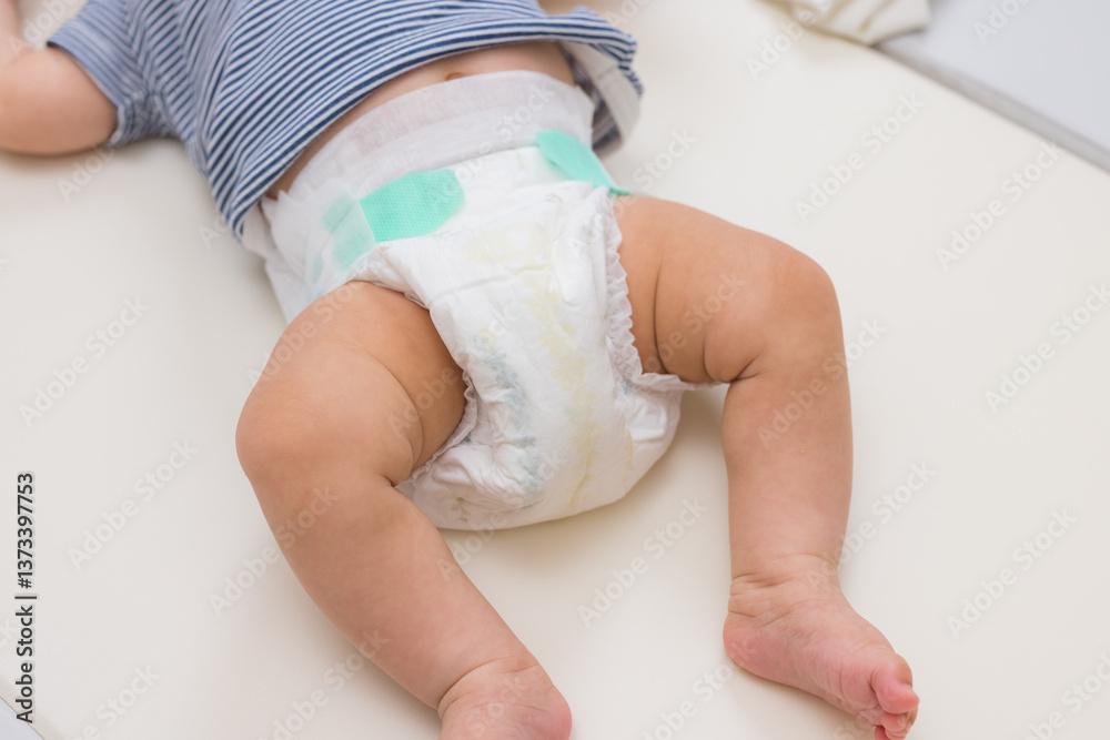 Close up of baby legs and diaper on table