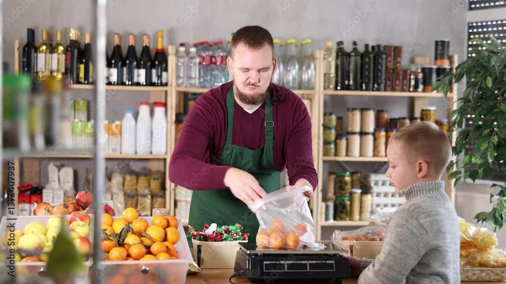 Young male seller weighs and sells tangerines to boy buyer in grocery store Young male seller weighs and sells tangerines to boy buyer in grocery store