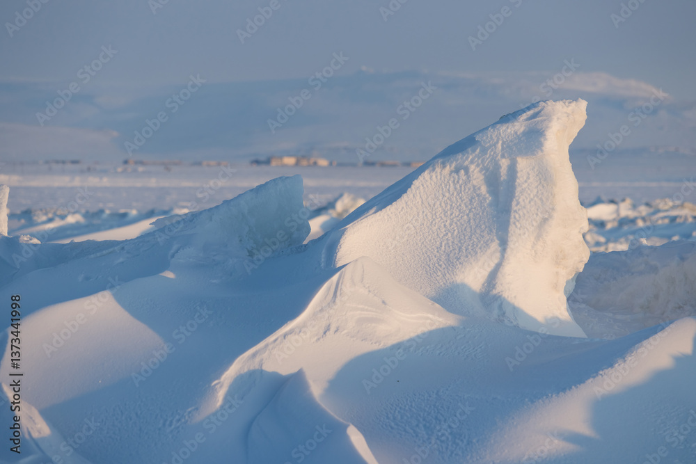 Winter arctic landscape. Ice hummocks on the frozen sea in the Arctic. View of snow and ice at sunset. Cold frosty winter weather. Harsh polar climate. Amazing nature in the far north in the Arctic.