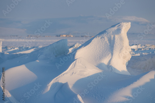 Obraz na płótnie Winter arctic landscape. Ice hummocks on the frozen sea in the Arctic. View of snow and ice at sunset. Cold frosty winter weather. Harsh polar climate. Amazing nature in the far north in the Arctic. w salonie
