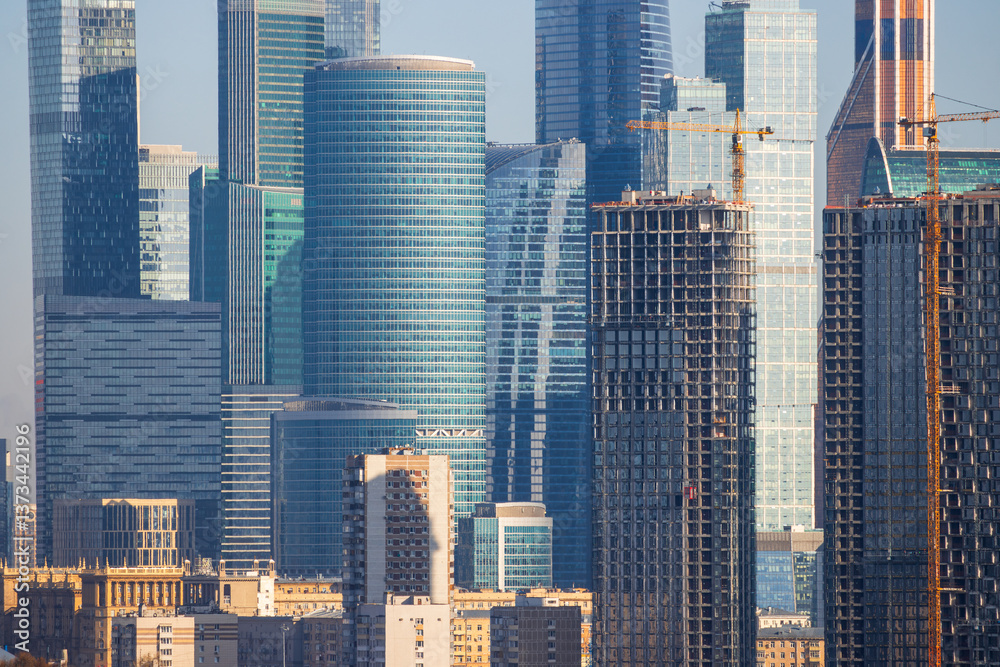 View of a city block in a modern city. Residential and administrative buildings close-up. Old houses and modern skyscrapers. Construction of high-rise buildings. Beautiful cityscape.