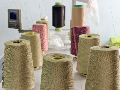 bobbins of cotton yarn on a knitting machine during the knitting process