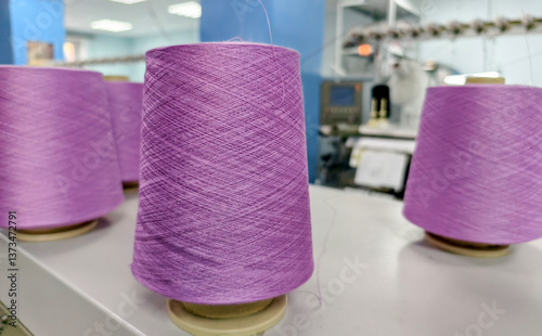 bobbins of cotton yarn on a knitting machine during the knitting process