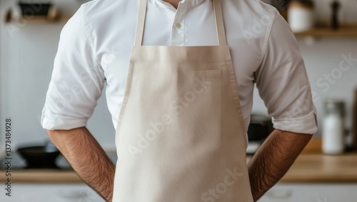 Fototapeta Naklejka Na Ścianę i Meble -  Male chef in a kitchen wearing a beige apron, exuding confidence and professionalism.