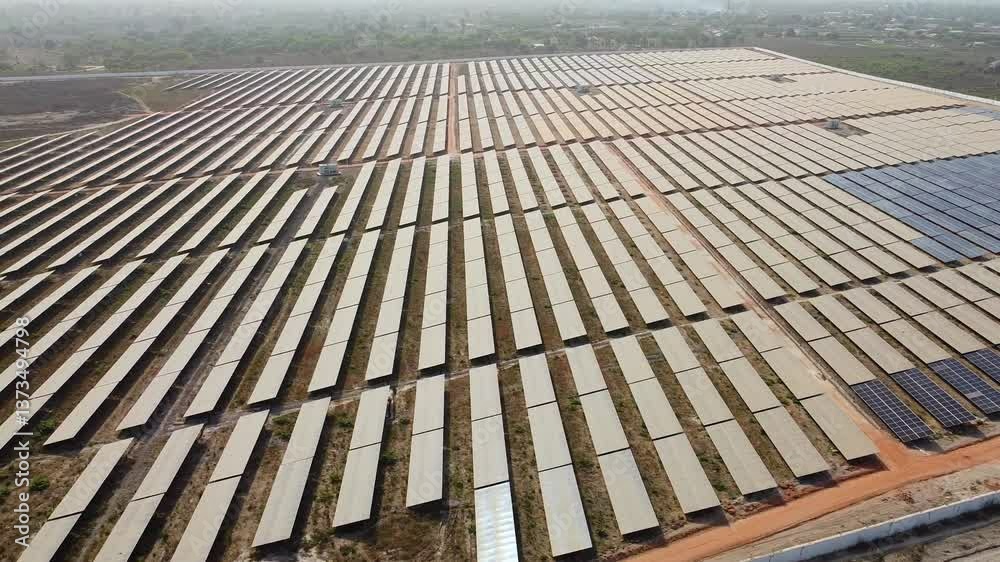 Extensive solar panel arrays at dust prone African project site showcasing the challenges of solar farms at sunset - aerial sliding overview Extensive solar panel arrays at dust prone African project site showcasing the challenges of solar farms at sunset - aerial sliding overview