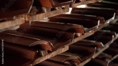 An Indonesian factory producing red clay roof tiles using ancient technology on the island of Bali. Many products are left on drying shelves.