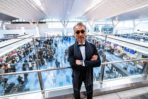 Obraz na płótnie 空港ターミナルでチェックインの手続きをする男性 w salonie