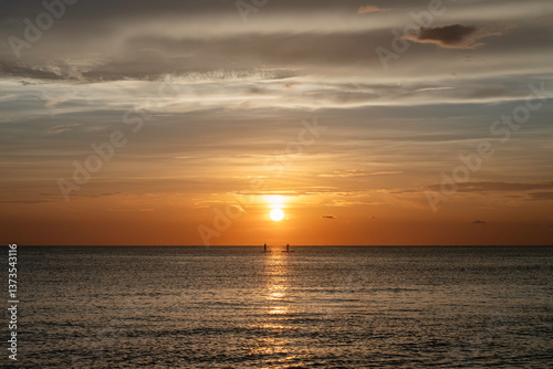 Two people on stand-up paddleboards, ocean sunset in Florida