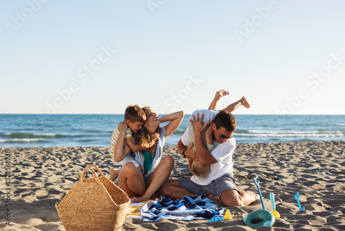 Billede på lærred Happy family playing together on the beach during summer vacation