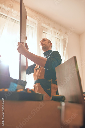Obraz na płótnie Carpenter working and assembling furniture in a new apartment. w salonie